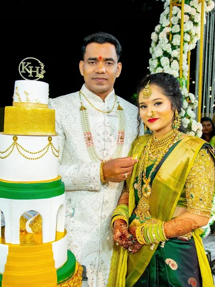 A beautiful portrait of the couple with their stunning multi-tiered cake, celebrating their Sakharpuda.