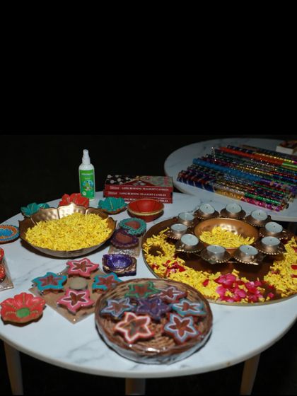 The setup for a festive celebration, featuring diyas, floral arrangements, and dandiya sticks ready for the guests. I take care of all the little details.