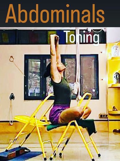 This pose uses the chair to assist in toning the abdominals through a combination of lifting and twisting. The arms extend upward, creating length in the spine while the core remains engaged and active.