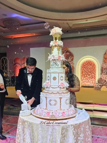 The couple prepares to cut their magnificent multi-tiered engagement cake. This shot captures the scale and grandeur of the cake within the context of the celebration.