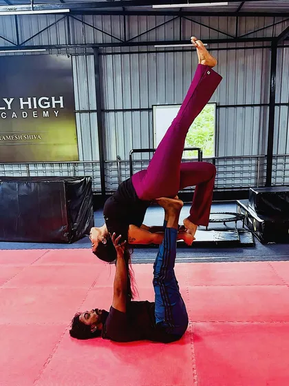 This acro yoga pose demonstrates incredible balance from the base and flexibility from the flyer.