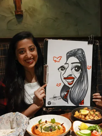 A beautiful smile and a fun caricature to match. The food in the foreground shows how this activity fits perfectly into a dining experience.