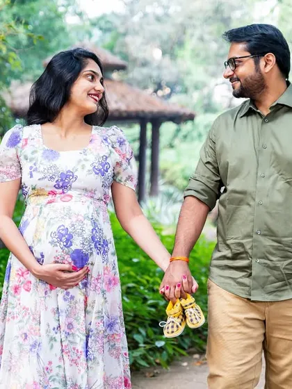 A simple and sweet moment. This couple walks hand-in-hand, holding tiny baby shoes, their smiles saying it all.
