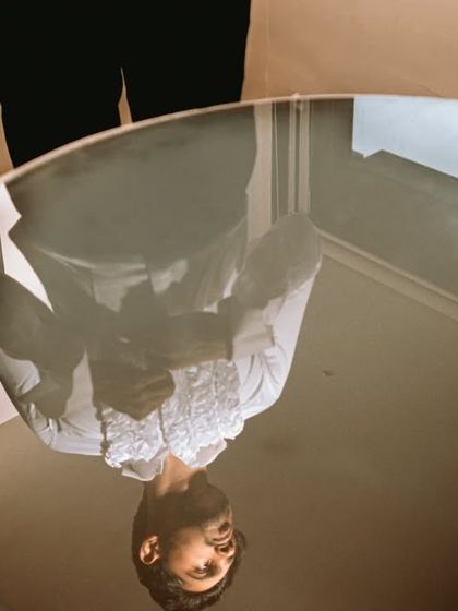 A creative portrait of the groom, using the reflection in a glass table to create an interesting, upside-down perspective.
