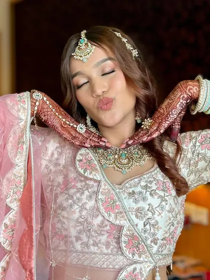 A playful and cute pose from the sister of the bride. Her rosy makeup and glowing skin make her look fresh and joyful.