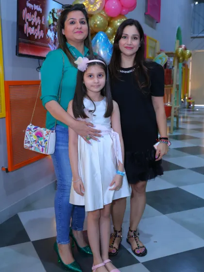 Two guests pose with the birthday girl at her special celebration.