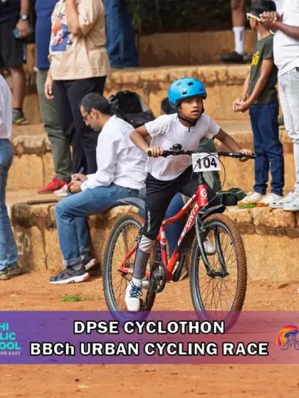 A young rider tackles the dirt track with spectators cheering in the background. The supportive community atmosphere is a hallmark of all my events.