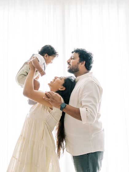 A family portrait against a bright, backlit window. The feeling of light and happiness fills this beautiful image.