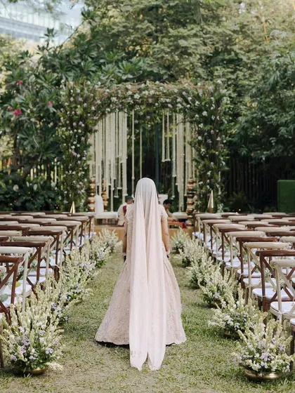 The bride's walk down the aisle, with the decor designed to feel like a natural extension of the enchanted garden.