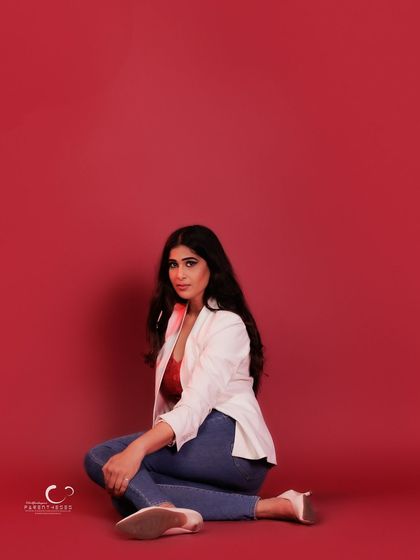 A low-angle shot that uses negative space to create a dramatic and minimalist composition. Her gaze is direct and captivating.