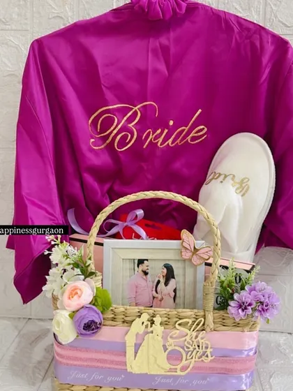 A special gift for a beautiful bride-to-be. This hamper includes a personalized satin 'Bride' robe, matching slippers, and a custom photo frame, creating a perfect pre-wedding pamper kit to celebrate her journey to the altar.