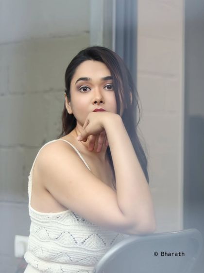 A thoughtful and composed portrait, shot through a slightly distorted foreground element for an artistic touch.