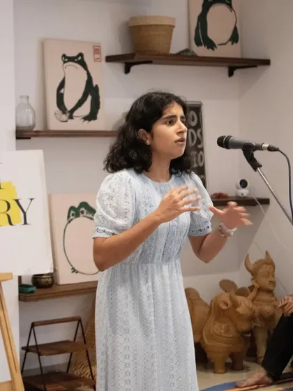 A young performer confidently taking the mic. We encourage artists of all ages to participate and share their unique perspectives with our supportive audience.