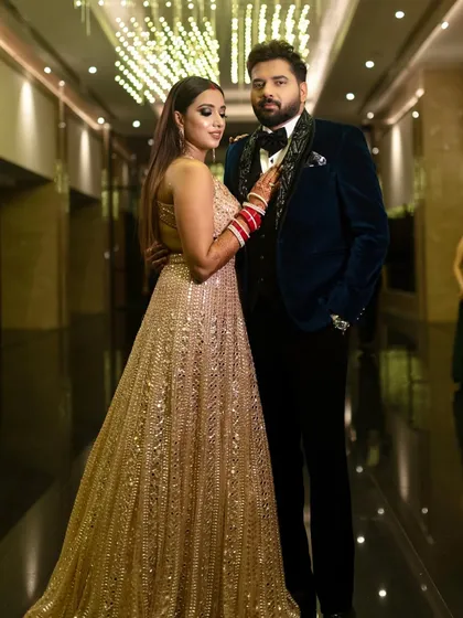 This reception bride looks absolutely stunning with her partner. Her makeup is glamorous, with a dramatic smokey eye and contoured features that photograph beautifully.