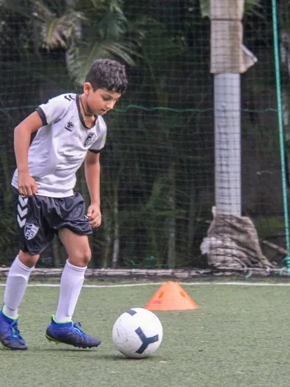 Eyes on the ball, a player dribbles with precision during a training drill, building the muscle memory needed for high-pressure game situations.