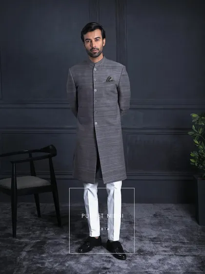 A regal expression in charcoal grey. This Matka silk achkan is paired with a paisley stole embroidered in tradition’s language. It is classic, royal, and timeless.