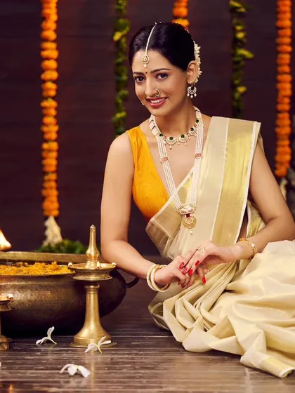 A direct-to-camera shot from the same traditional jewellery campaign. The model's warm smile and the beautifully arranged festive setting create an inviting and culturally rich image for the brand.