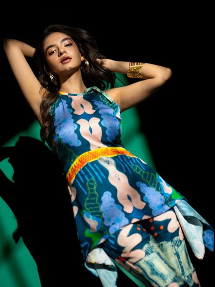 A reclining pose that showcases the pattern of the outfit, with the dramatic lighting creating interesting shapes and shadows.