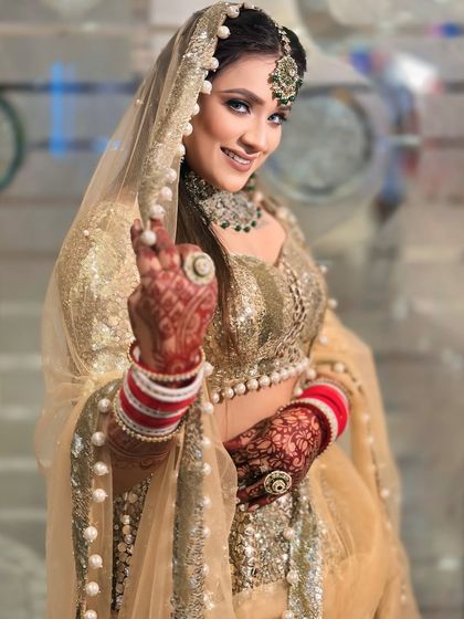 A happy, smiling bride in our golden sequin lehenga. The red choora (bangles) adds a beautiful pop of traditional color.