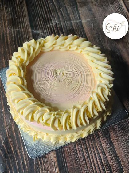 A top-down view of the smash cake, showing the lovely texture of the piped buttercream border and the soft ombre center.