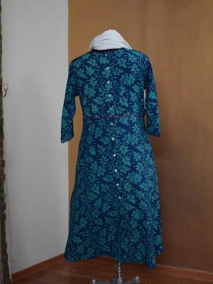 The back of the blue floral kurti shows the continuation of the print and a simple, clean finish with button details, ensuring you look great from every angle.