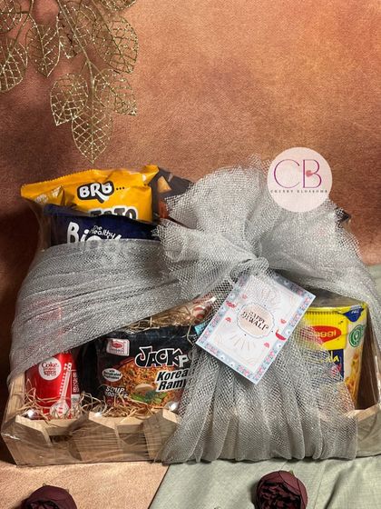 Spreading light and laughter this Diwali. This confectionery hamper is packed with a variety of snacks like Korean ramen, Binge chips, and Coca-Cola, all wrapped up in a beautiful pinewood tray.