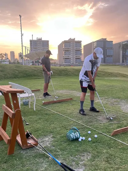 Players practicing their short game against the backdrop of a beautiful sunset. Our natural grass areas are perfect for honing all aspects of your game.