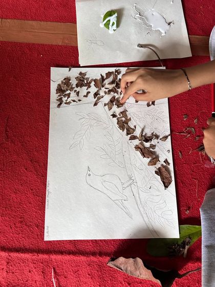 A participant gets creative with nature painting, using leaves and twigs to make art. This activity is part of our Nature Awareness Camp at Ulavi.