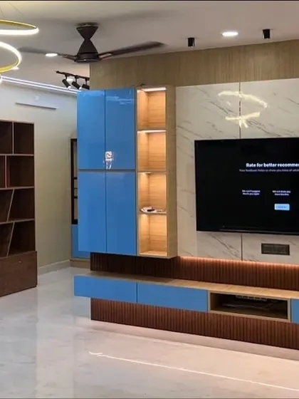 A wider view of the blue and marble-finish TV unit, showing how it integrates with an open-plan living space. The design also includes a large wooden bookshelf, providing ample storage and display area.