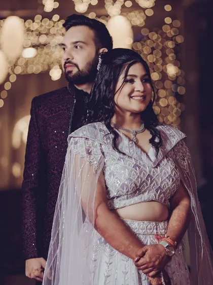 A beautiful portrait of the couple at their Sangeet. Her makeup is glamorous yet elegant, complementing her modern caped lehenga.