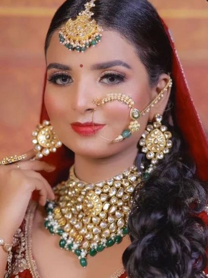 A classic bridal portrait. The model wears a heavy Kundan and pearl set with a red lehenga, a timeless combination.