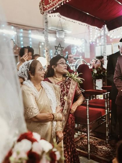 During a Jewish wedding ceremony, the groom sings to his bride as she approaches. The look on his face is one of pure adoration.