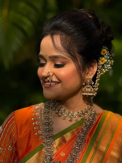 This bride's smile says it all. Her traditional bun is adorned with fresh flowers, a classic choice for a Maharashtrian wedding that adds natural beauty and fragrance.