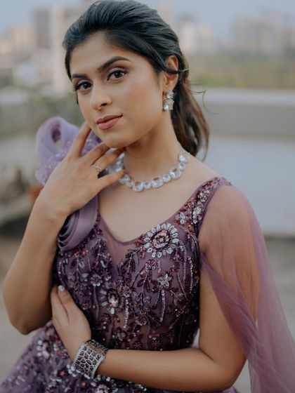 A close-up portrait of the bride in her glamorous Sangeet gown. The focus is on her elegant makeup, jewelry, and the intricate details of her outfit.