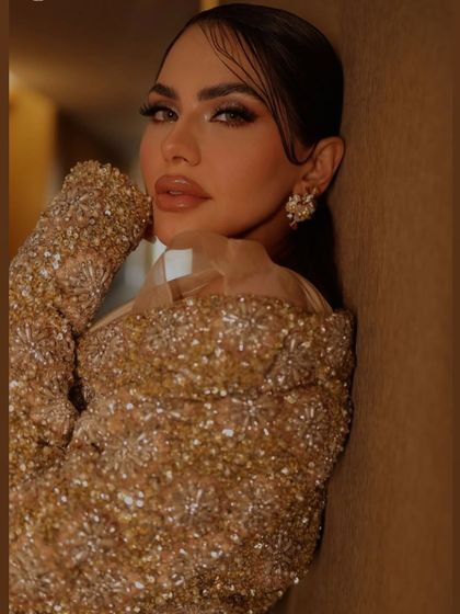 A wet-look updo with styled tendrils for a high-fashion shoot. This edgy and modern style is perfect for editorial work that calls for a bold, confident look.