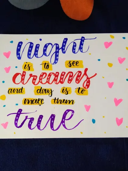 A colorful calligraphy piece with the quote "Night is to see dreams and day is to make them true."
