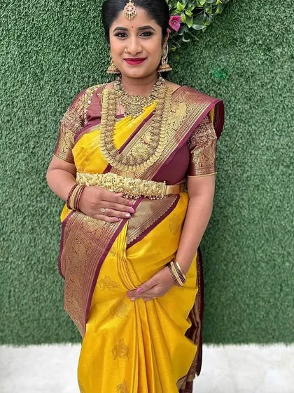 A full view of Deepika's baby shower look. The traditional temple jewelry and rich silk saree create an aura of divine grace.