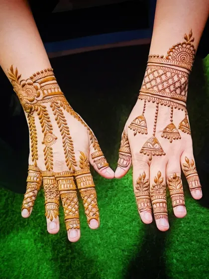 A minimalist yet striking back-of-hand mehandi design. Featuring delicate hanging jhumka (bell) motifs and a simple wristband, this style is perfect for guests or for those who love understated elegance.