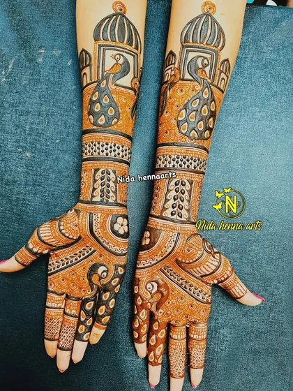 This elegant design features peacocks as the central theme. A large peacock sits on the wrist, with smaller peacock motifs on the palm, creating a graceful and cohesive design.