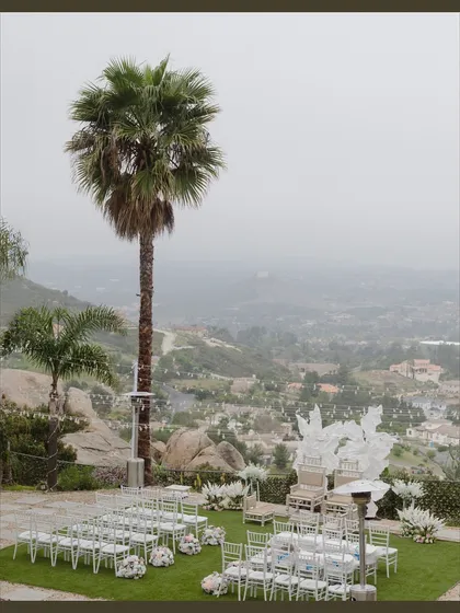 An intimate ceremony with a breathtaking view. I designed this backyard wedding setup in San Diego to be simple and elegant, with white chairs and floral arrangements that wouldn't distract from the stunning natural landscape.