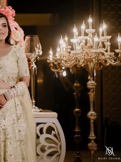 A lovely portrait of the bride by an ornate candelabra at her engagement party. The warm lighting creates a soft and romantic mood.