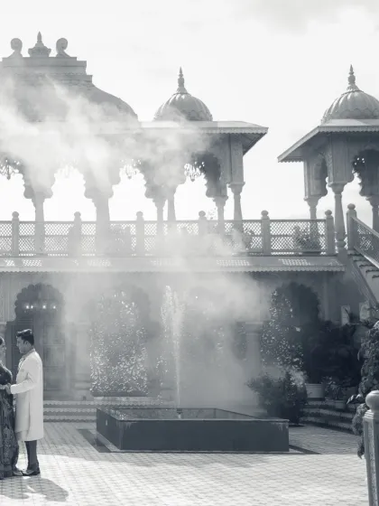 A dreamy, black and white photograph that gives a timeless feel to this royal shoot. The mist around the fountain adds a layer of mystique and romance to the palace courtyard scene.