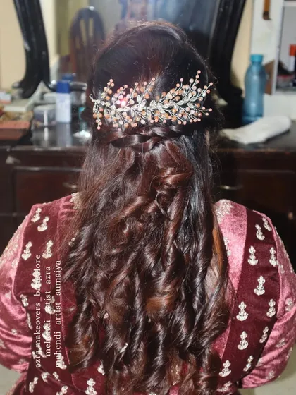 My services include complete hairstyling to match your makeup. Here is an example of a half-up, half-down style with soft curls and a braided detail, finished with an elegant hair accessory for a polished party look.