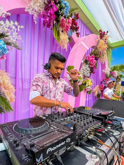 A focused shot of me at the decks during a daytime fusion set. In the background, you can see the percussionist ready to jump in, highlighting the collaborative nature of our performance.