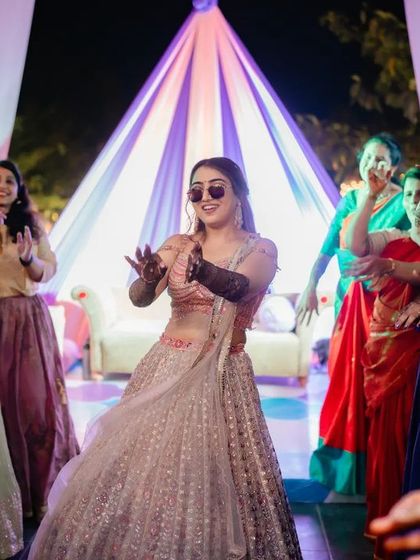 Nothing beats the energy of a mehndi party. A happy client takes center stage on the dance floor, her henna adding to the festive vibe.