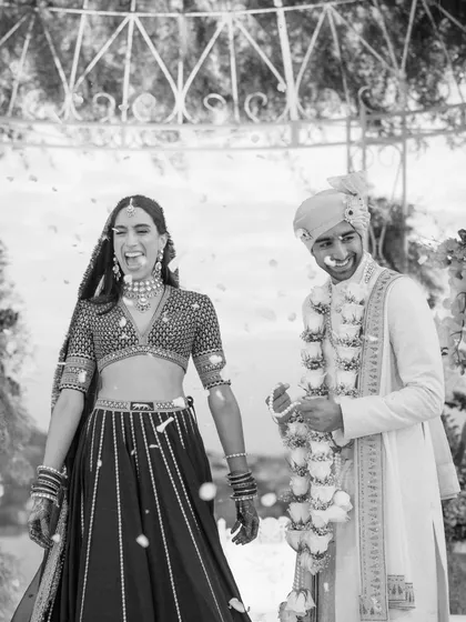 The pure, uninhibited joy of a couple showered with petals just after their vows. This black and white shot captures the raw emotion and happiness that is the true essence of a wedding.