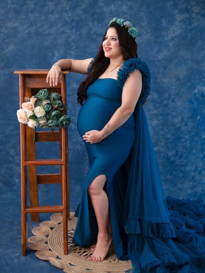 This royal blue mermaid gown is both sleek and dramatic. The fitted silhouette beautifully highlights the baby bump, while the tulle train adds a touch of glamour. It's a perfect choice for a sophisticated, high-fashion look.