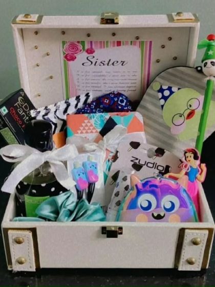 Another "Sis-star" hamper in a white trunk. It's filled with a unique collection of gifts to surprise and delight a special sister.