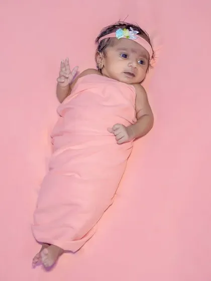 A full-length shot of a newborn wrapped in pink. This shows a simple and clean setup that is perfect for creating classic baby portraits.