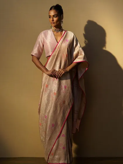 A beautiful handwoven saree in pastel pink and cream, paired with a simple pink blouse. This look is all about understated elegance and the beauty of craftsmanship.